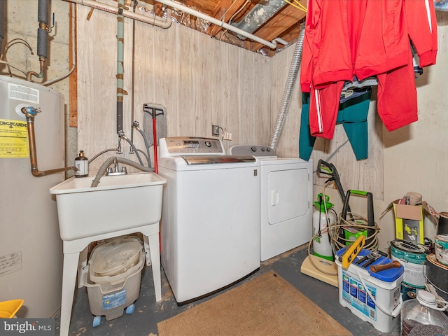 clothes washing area featuring gas water heater and washing machine and clothes dryer