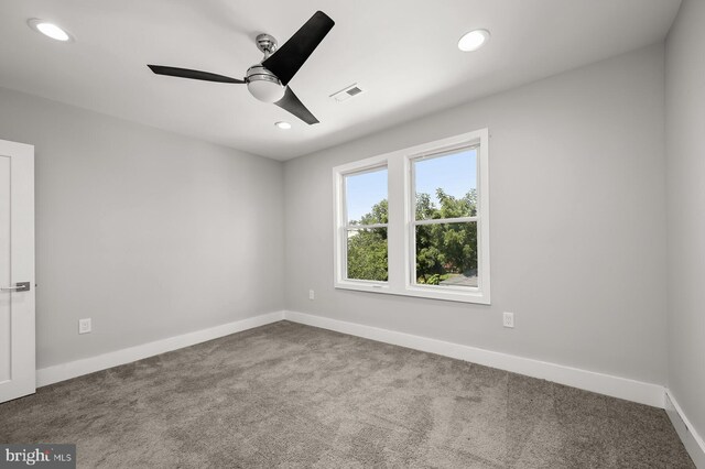 carpeted spare room featuring ceiling fan