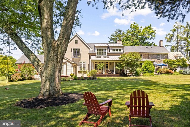 rear view of house featuring a yard