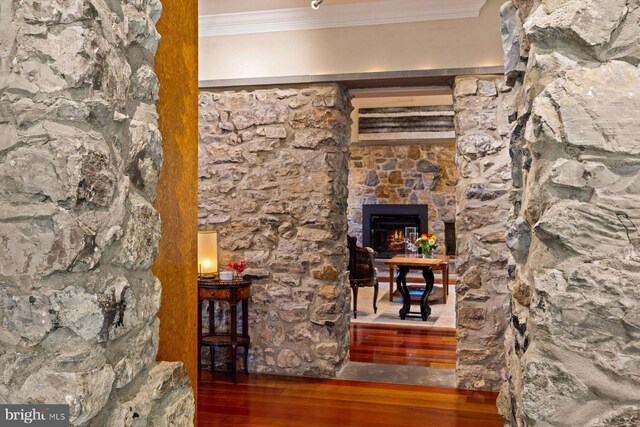 interior space with a fireplace, crown molding, and wood-type flooring