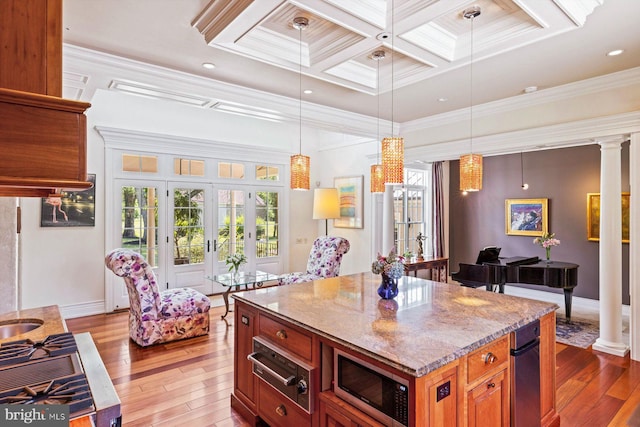 kitchen featuring coffered ceiling, crown molding, light wood-type flooring, and ornate columns