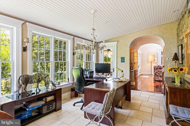 office space featuring a healthy amount of sunlight, vaulted ceiling, and light hardwood / wood-style floors