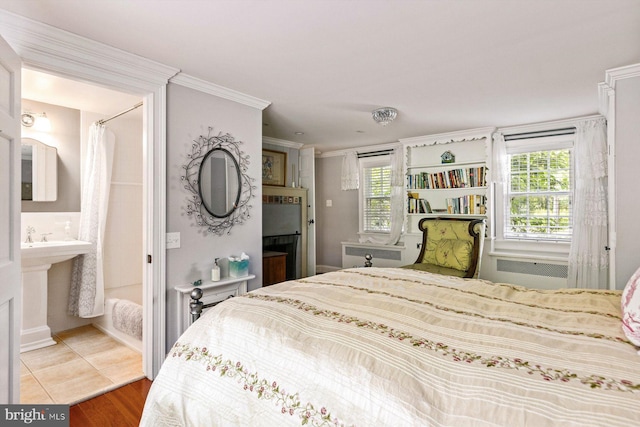 bedroom with crown molding, hardwood / wood-style floors, and connected bathroom