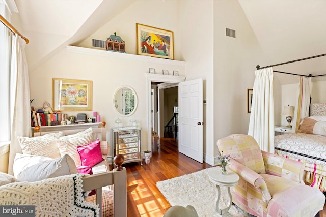 living room featuring high vaulted ceiling and hardwood / wood-style floors