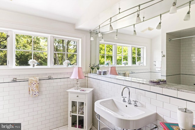 bathroom featuring tile walls, tile patterned floors, and sink