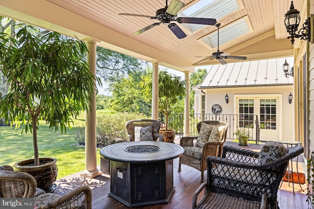 sunroom featuring ceiling fan and vaulted ceiling with skylight