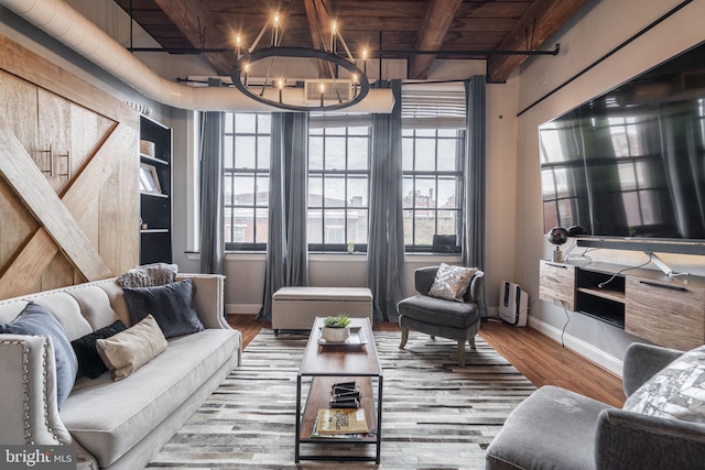 living room featuring beam ceiling, wood-type flooring, wood ceiling, and a chandelier