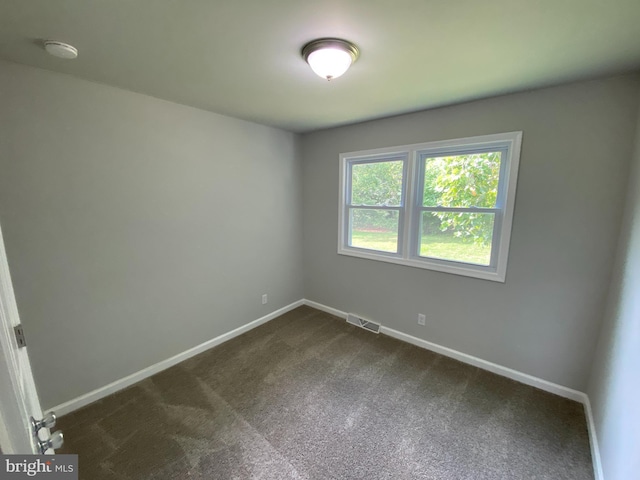 empty room featuring dark colored carpet