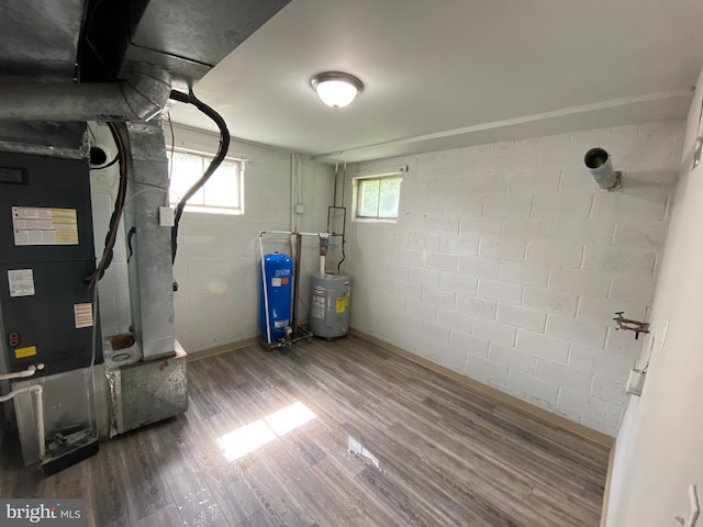 utility room featuring heating unit and electric water heater