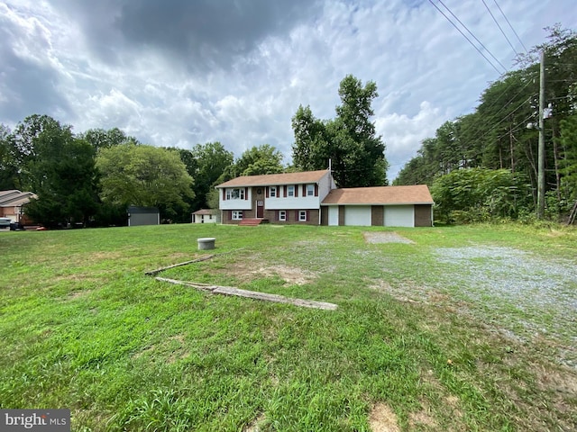 view of front of house with a garage, an outbuilding, and a front yard