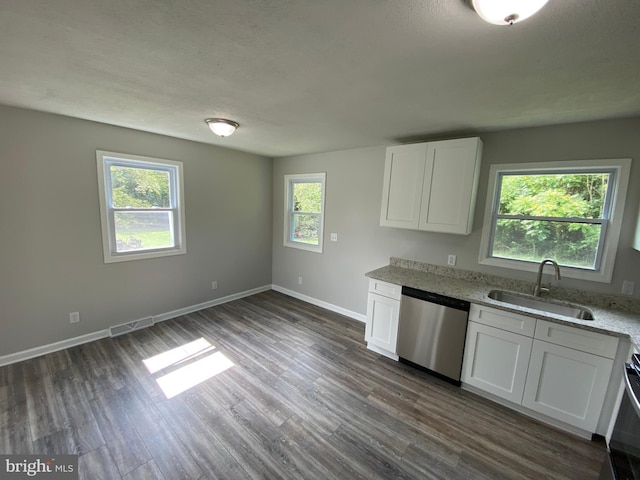 kitchen with sink, light stone countertops, white cabinets, dark hardwood / wood-style flooring, and stainless steel dishwasher