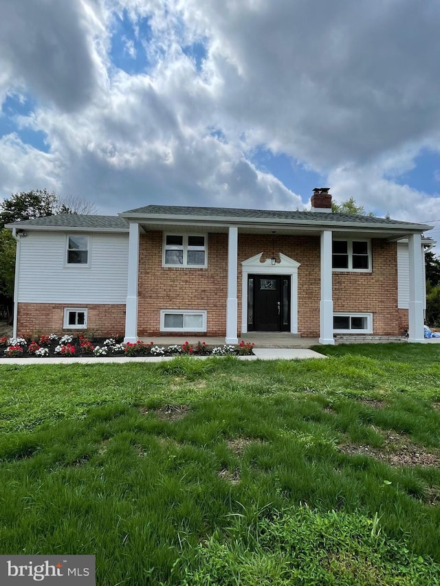 rear view of property with a lawn