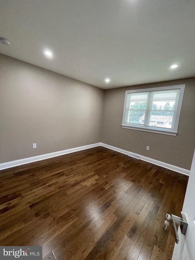 unfurnished room featuring dark wood-type flooring