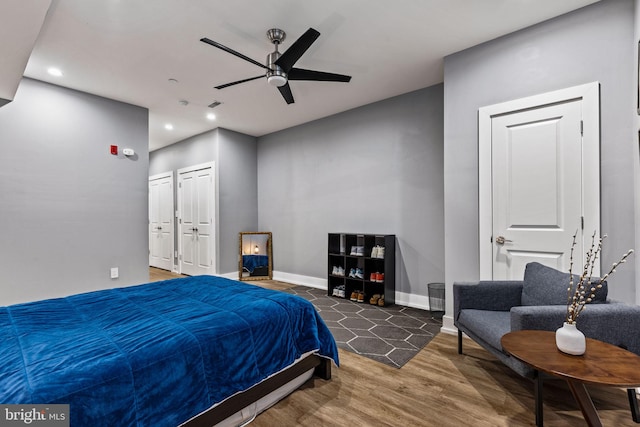 bedroom with dark hardwood / wood-style flooring and ceiling fan