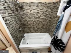 bathroom with tiled shower / bath combo