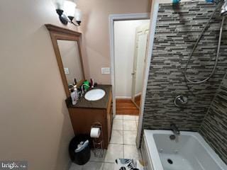 bathroom with tile patterned floors, tiled shower / bath combo, and vanity