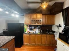 kitchen with sink, black fridge, and light wood-type flooring