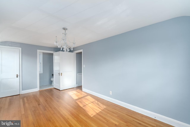 unfurnished bedroom featuring light hardwood / wood-style flooring and a notable chandelier