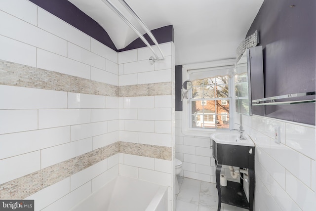 full bathroom featuring lofted ceiling, tile walls, vanity,  shower combination, and toilet