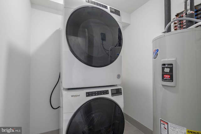 washroom featuring electric water heater and stacked washer and clothes dryer