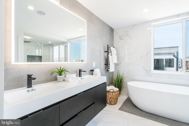 bathroom with tile walls, tile patterned floors, and double sink vanity