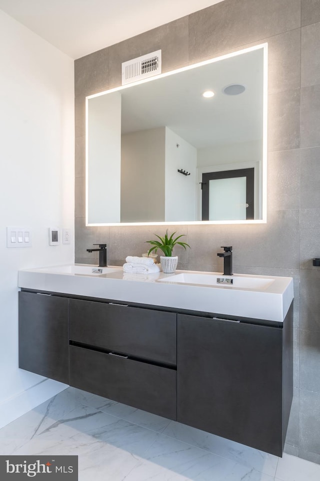 bathroom with double sink vanity, tile walls, and tile patterned flooring