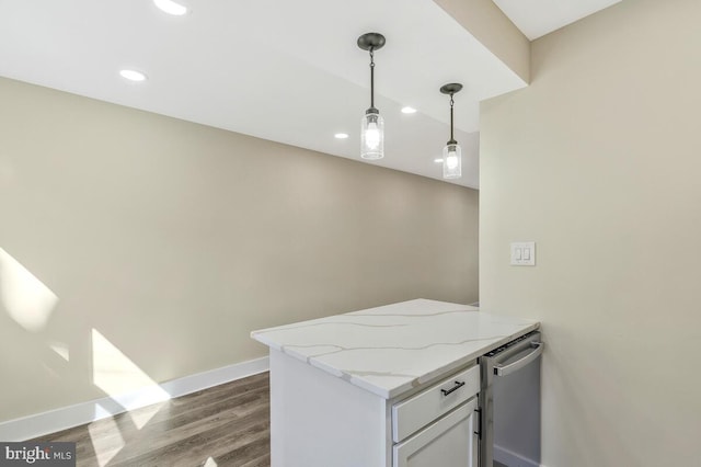 kitchen with light stone counters, dark wood-style flooring, white cabinetry, baseboards, and hanging light fixtures