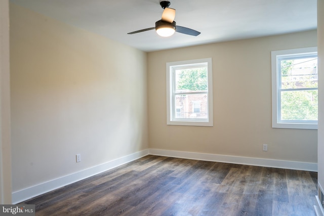 empty room featuring dark wood-style floors, ceiling fan, and baseboards