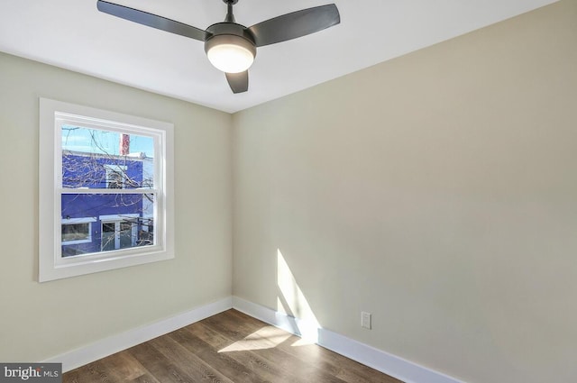 unfurnished room with dark wood-style floors, ceiling fan, and baseboards