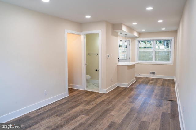 unfurnished bedroom featuring dark hardwood / wood-style flooring and ensuite bathroom