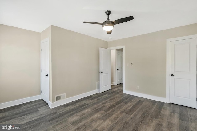 unfurnished bedroom featuring a ceiling fan, dark wood-style flooring, visible vents, and baseboards