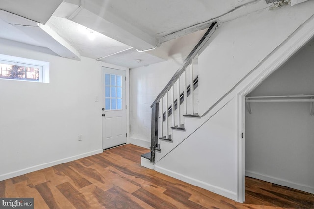 foyer entrance with stairway, baseboards, and wood finished floors