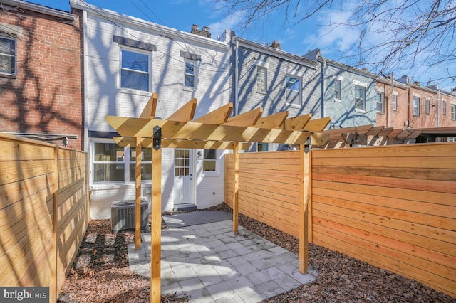 view of patio / terrace with central AC unit, a fenced backyard, and a pergola