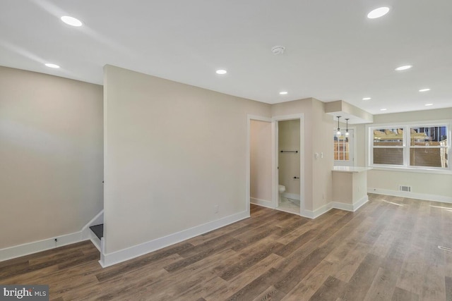 empty room with visible vents, baseboards, dark wood finished floors, and recessed lighting