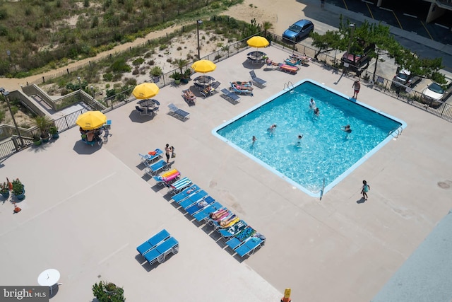 view of swimming pool with a patio area and fence