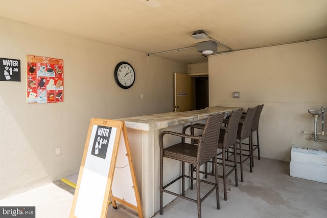 bar featuring unfinished concrete floors