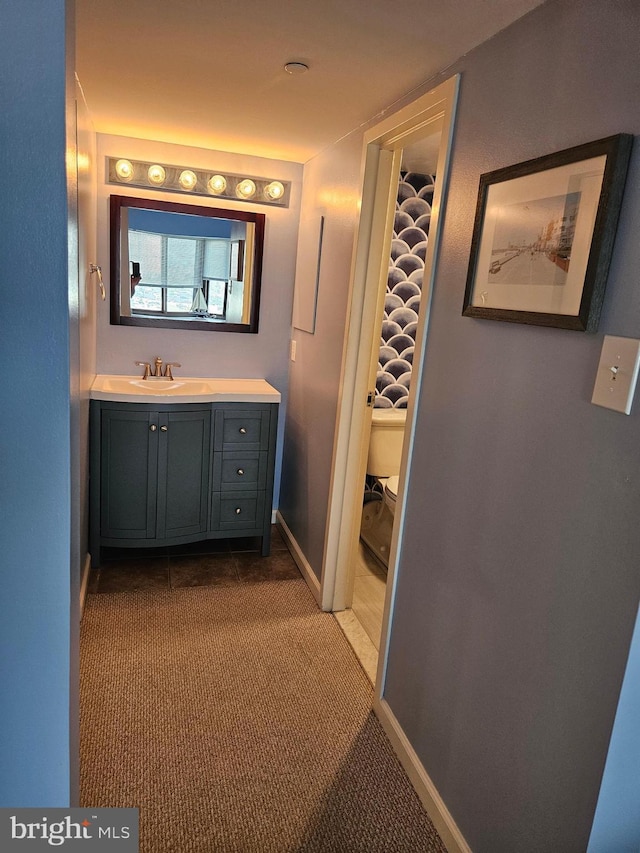 bathroom featuring baseboards, vanity, and toilet