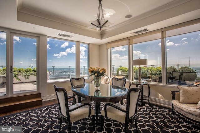 sunroom / solarium featuring a raised ceiling and an inviting chandelier