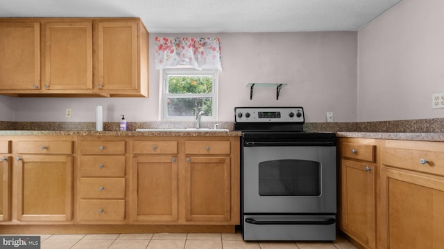 kitchen featuring stainless steel electric stove, sink, light tile patterned floors, and a textured ceiling