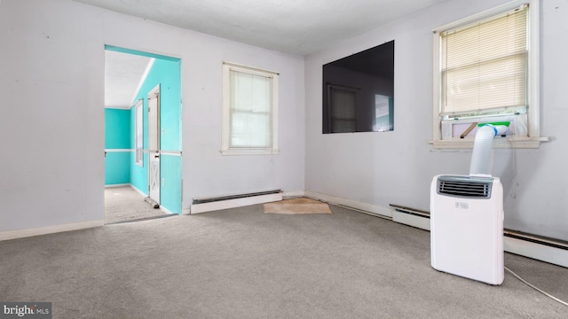 unfurnished room featuring a healthy amount of sunlight and a baseboard heating unit