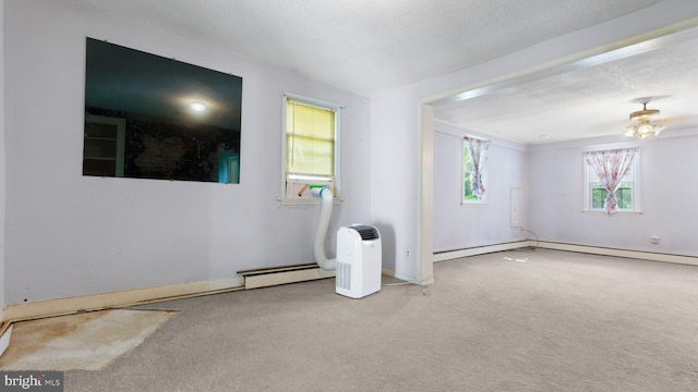 carpeted spare room with baseboard heating and a textured ceiling