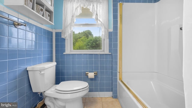 bathroom featuring tile patterned floors, toilet, shower / bathing tub combination, and tile walls