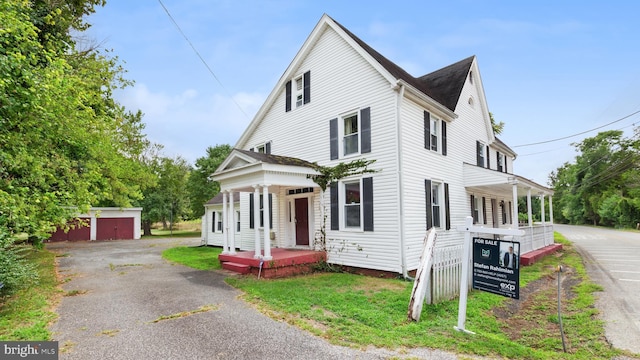 view of front of property with an outdoor structure and covered porch