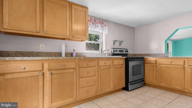 kitchen with light tile patterned flooring, sink, stainless steel range with electric cooktop, and a textured ceiling