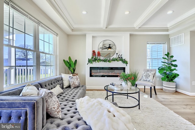 living room with ornamental molding, ceiling fan, beam ceiling, and light hardwood / wood-style flooring