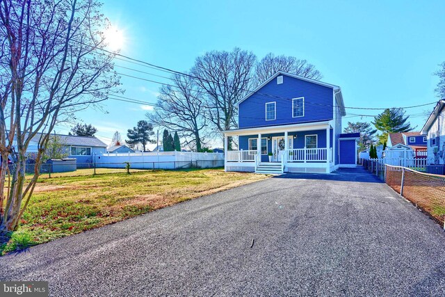 view of front of house with covered porch and a front lawn