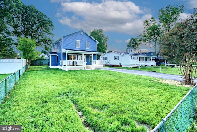 rear view of property with a porch and a yard