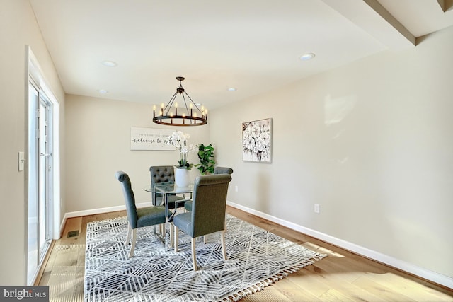 dining area with an inviting chandelier and light wood-type flooring