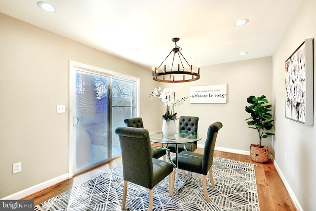 dining space featuring hardwood / wood-style flooring and an inviting chandelier