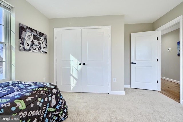 bedroom with light carpet and a closet